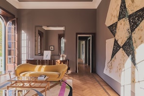 A modern living room with a sofa, coffee table, and artwork on the wall.