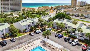 Un resort con piscina, edificios de varios pisos y vistas a la playa.