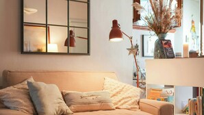 Una sala de estar acogedora con sofá, mesa de centro, lámpara y estantería.