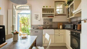 Una cocina con comedor, microondas, hervidor de agua y lavavajillas.