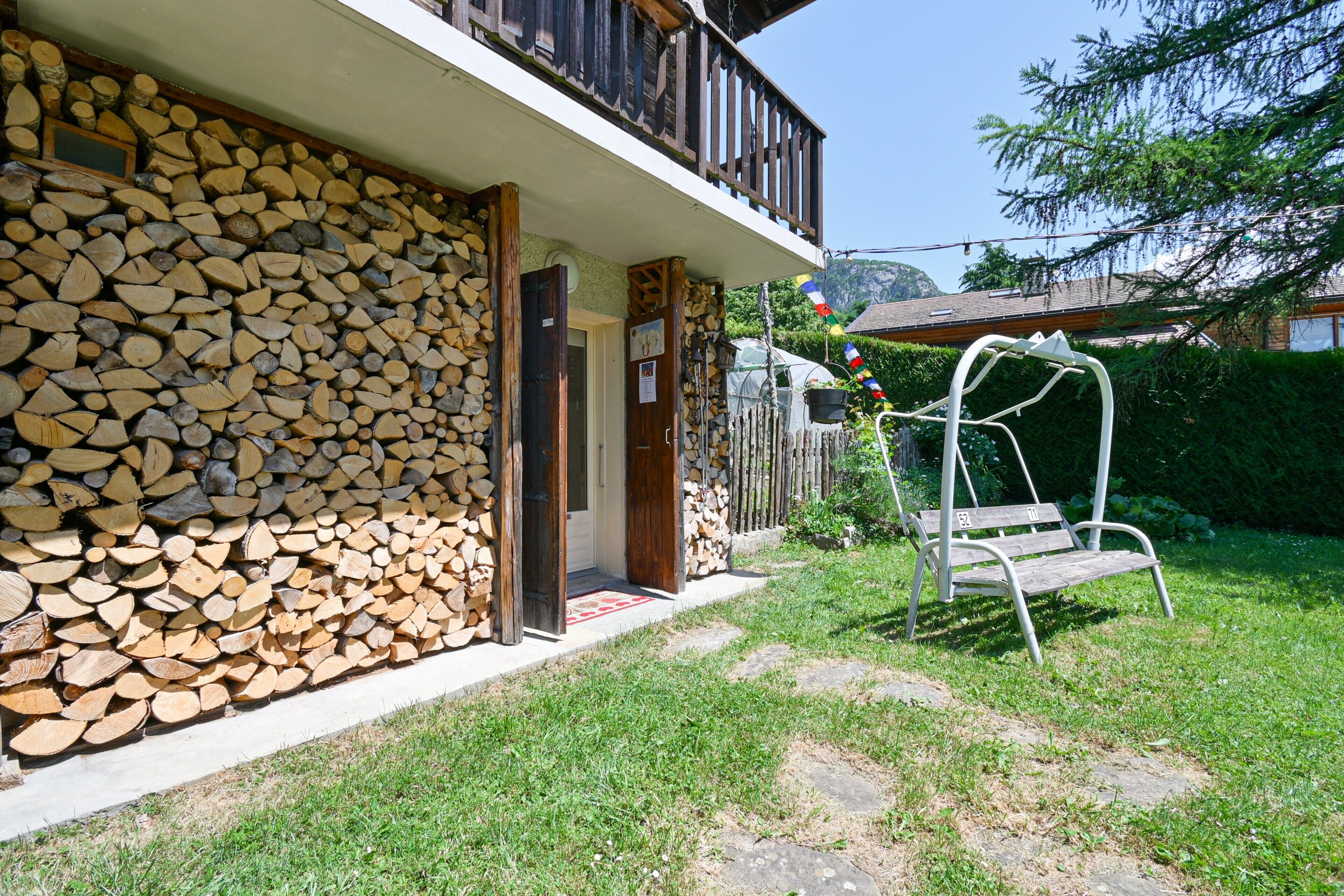Ein Haus mit einer Steinmauer, einer Holzdiele und einer Schaukel.