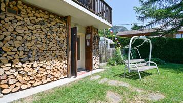 Ein Haus mit einer Steinmauer, einer Holzdiele und einer Schaukel.