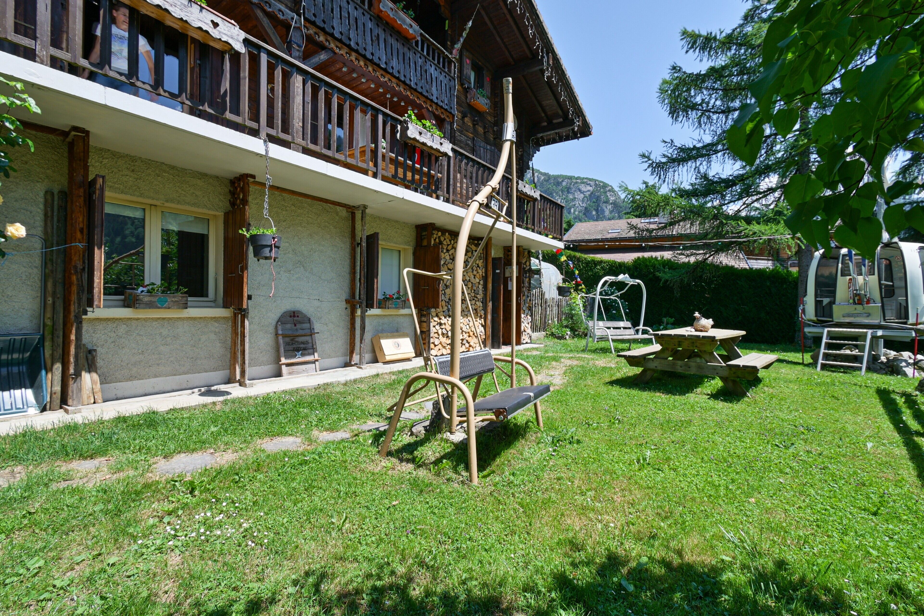 A chalet with a balcony, a wooden deck, and a picnic table.