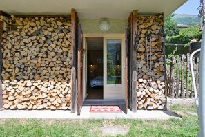 A wooden exterior wall with a door leading to a room.