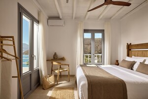 Un dormitorio con cama, escritorio, silla, ventana con vistas y ventilador de techo.