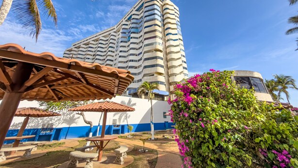 Un hotel moderno de altura, con balcones y una vista despejada del cielo.