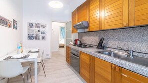 A modern kitchen with wooden cabinets, a granite countertop, and a stainless steel sink. - Cool stay at 2 steps from Duomo, Como (Como)