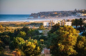 A coastal view with buildings, a lighthouse, and a beach. - Studio Apartment With Pool Meia Praia Beach, Lagos (Lagos)