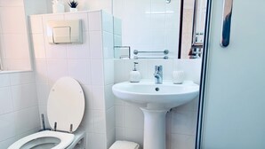 A bathroom with a toilet, sink, and a small trash bin. - Studio Apartment With Pool Meia Praia Beach, Lagos (Lagos)