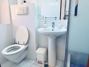 A bathroom with a toilet, sink, and a small trash bin. - Studio Apartment With Pool Meia Praia Beach, Lagos (Lagos)