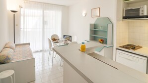 Una cocina moderna con comedor, sofá y microondas.