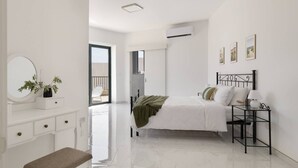 Un dormitorio moderno con cama, mesita de noche y un banco.