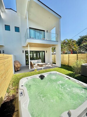 Ein modernes, zweistöckiges Haus mit Whirlpool im Garten.