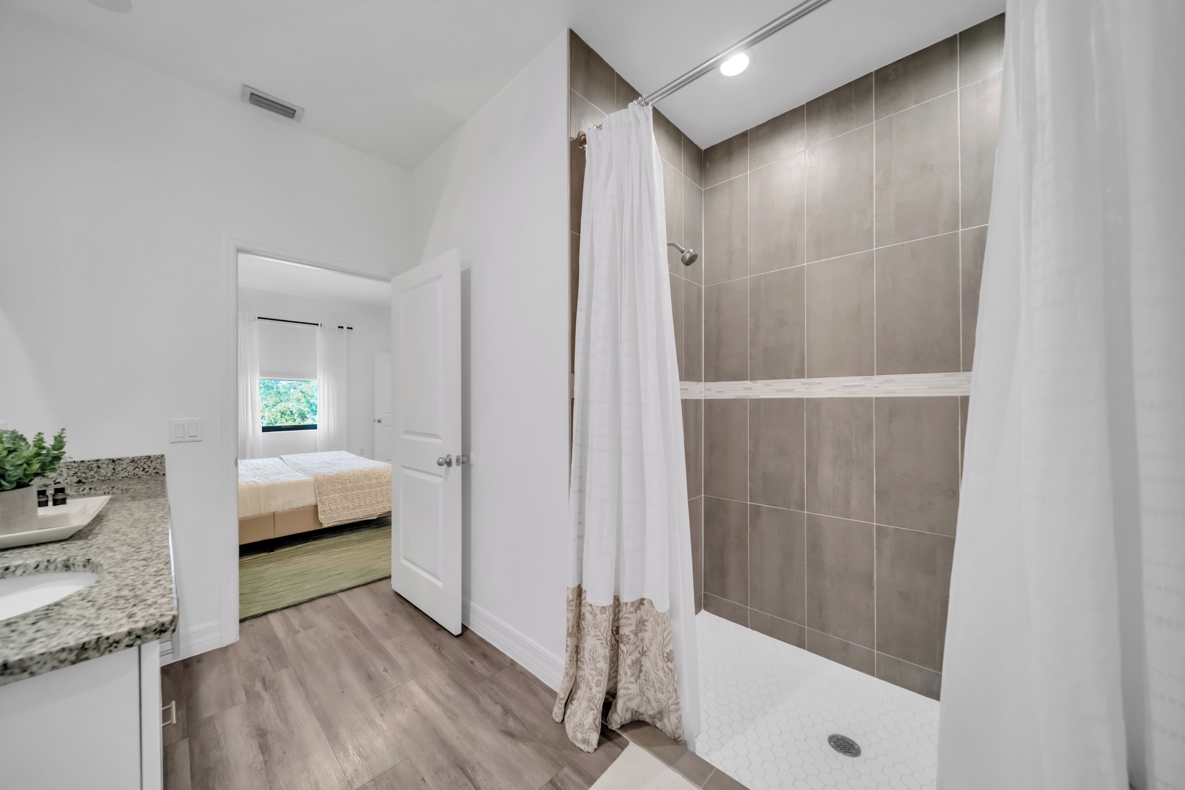 A modern bathroom with a shower, a sink, and a toilet.