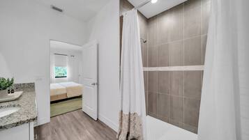 A modern bathroom with a shower, a sink, and a toilet.