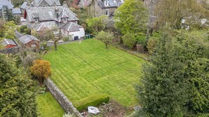 A residential area with houses, a well-maintained lawn, and a stone wall. - Edengrove (Aberfeldy)