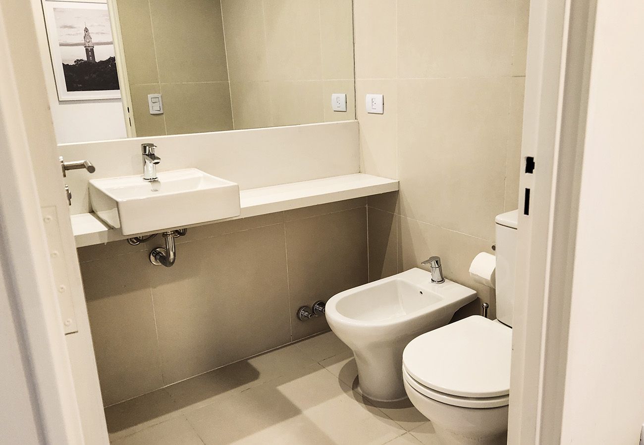 A bathroom with a toilet, bidet, and sink.