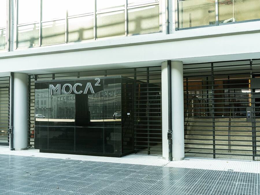 A modern building facade with a glass entrance and the signage 'MOC A2'.