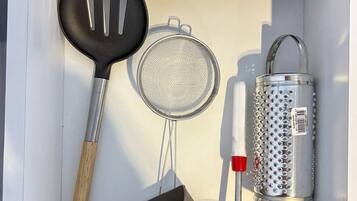 A kitchen area with a black spatula, a metal grater, and a metal strainer.