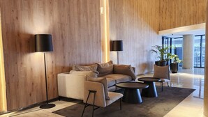 A modern living room with a sofa, two armchairs, a coffee table, and two floor lamps.