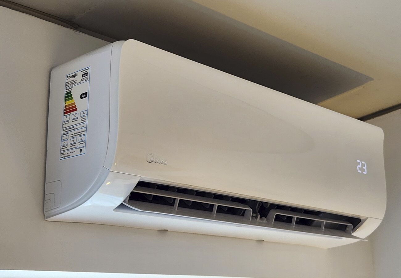 A wall-mounted air conditioner with a digital display, energy efficiency label, and a control panel.