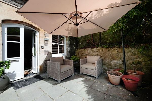 The garden features comfortable outdoor furniture for relaxing and enjoying the fresh air