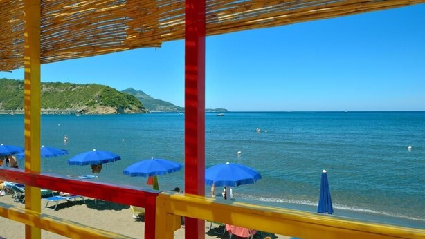 Une plage avec des parasols et une structure en bois.