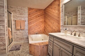 A bathroom with a wooden wall, a bathtub, a sink, and a mirror. - Spacious 3 bdrm, 2 Bath Plus Loft, 1630 Sq Ft.  Many onsite amenities with Golf/Skiing near by! (Harbor Springs)
