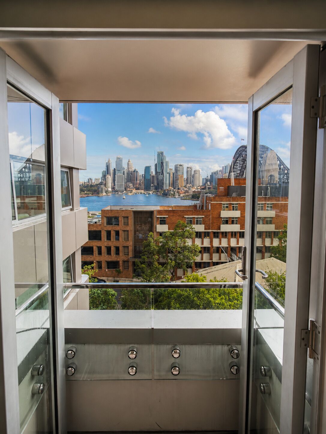 A balcony with a city view, including a body of water and buildings.