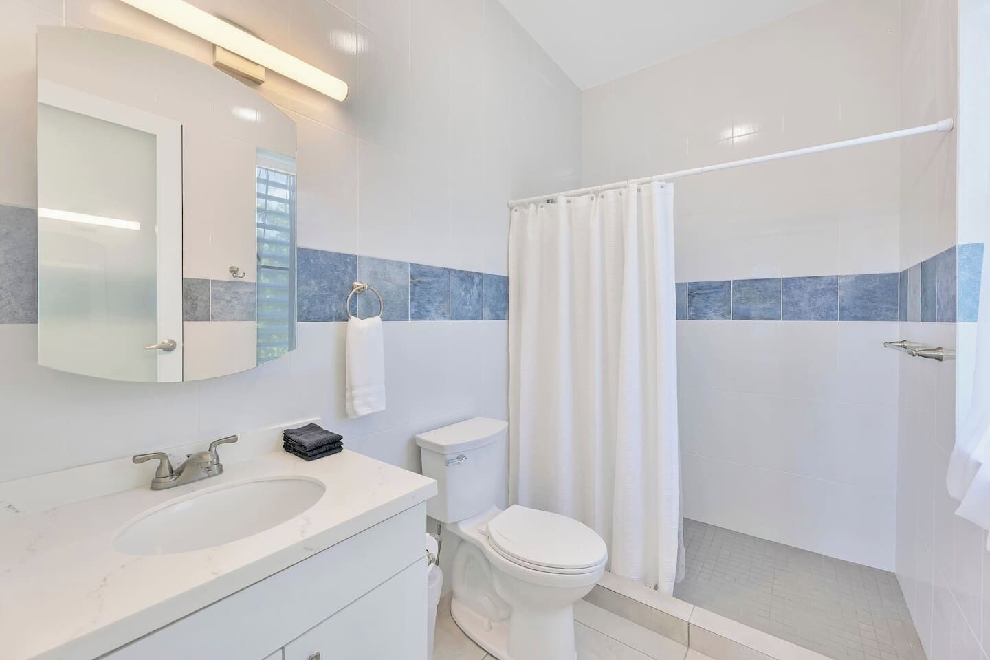 A modern bathroom with a sink, toilet, and shower.