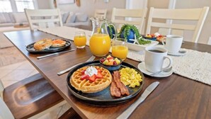 A breakfast setting with waffles, bacon, scrambled eggs, and fruit. - Silver Sand Dollar - Channel House - Firepit (North Myrtle Beach)
