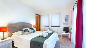 Een hotelkamer met een bed, nachtkastjes, een televisie en een raam.