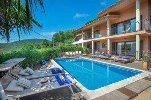 Ein Poolbereich mit Liegestühlen, einem Pool und einem Gebäude mit Balkonen.
