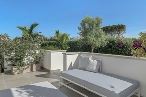 A rooftop terrace with a white bed, potted plants, and a clear blue sky. - Modern villa with pool in Fontane Bianche (Siracusa)