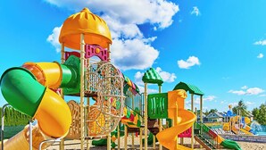 A playground with various play structures including slides and climbing areas.