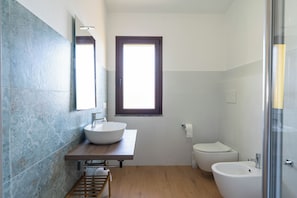 Ein modernes Badezimmer mit einem großzügigen Waschbecken, einer Toilette und einem Bidet.