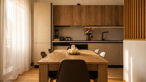Una cocina moderna con armarios de madera, una mesa de comedor con sillas y un florero sobre la encimera.