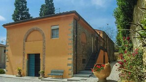 A building with a stone facade, a blue door, and a bench outside. - Violetta Apartment near Lucca (Segromigno in Monte)