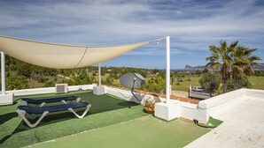 Eine Dachterrasse mit Liegestühlen, einer Satellitenschüssel und Blick auf die Landschaft.