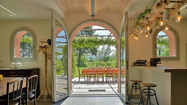Een modern interieur met een eethoek, keuken en grote ramen met uitzicht op de omgeving.