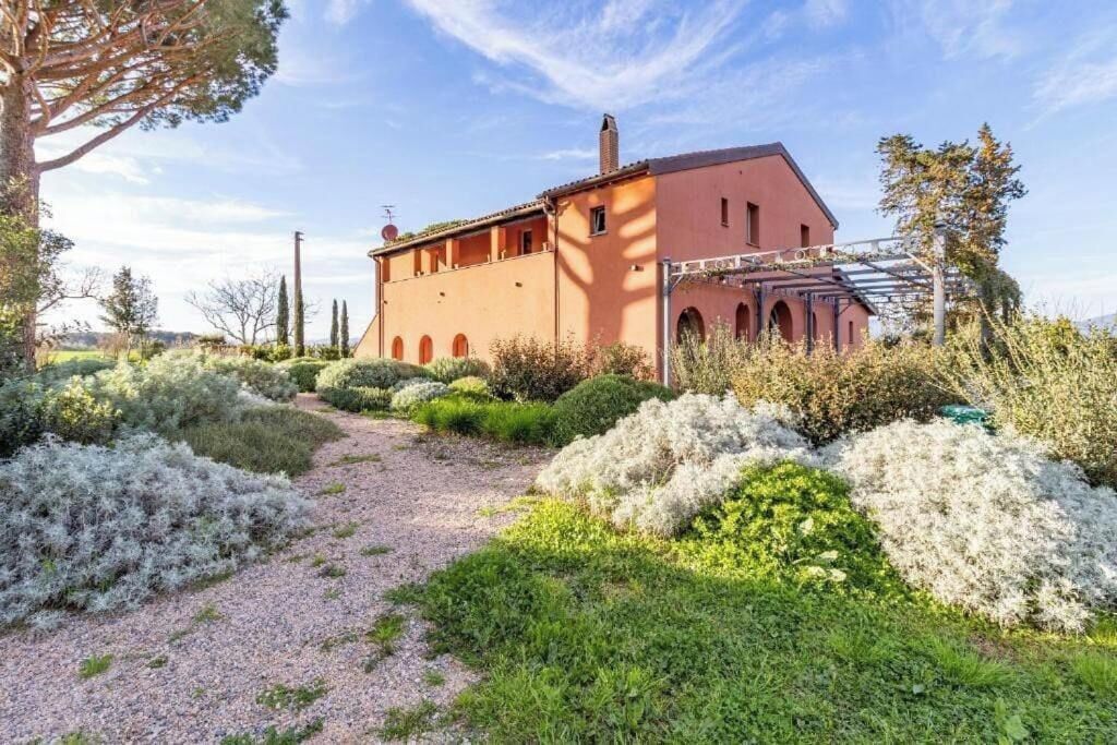 Ein Gebäude mit einem Gartenweg, der zu einem Bauwerk mit Bogenfenstern und einer roten Fassade führt.