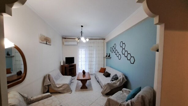 A room with two beds, a TV, a table, and a mirror.