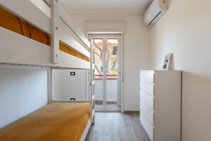 A bedroom with a bunk bed, a dresser, and a door leading to a balcony. - A comfortable 90 sqm apartment on two levels connected by an internal staircase, ideal for up to 6 people.The property is located in Torre Faro, one of the most picturesque towns in the Messina area, about 15 km from the center of Messina, at a point whe (Messina)