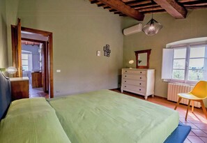 A bedroom with a bed, dresser, chair, and a window with a view. - Apartment with view in Segromigno in Monte (Segromigno in Monte)
