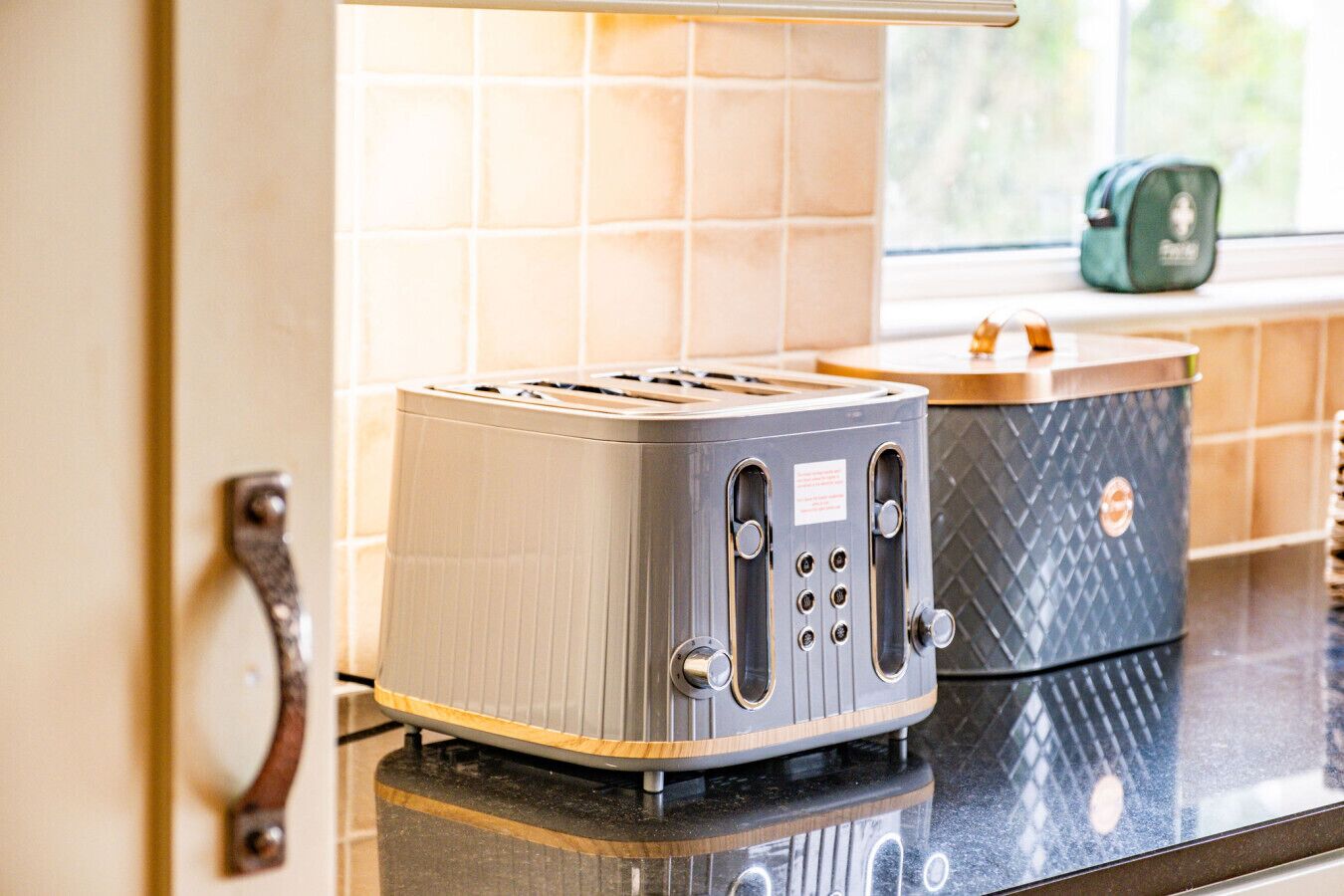 Una cocina con un tostador moderno y una cafetera sobre la encimera.