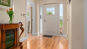 A hallway with wooden flooring, a white door, and a framed painting on the wall. - Hilltop View by Escape Ordinary (Lisbellaw, Enniskillen)