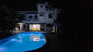 Una piscina grande con una casa al fondo.