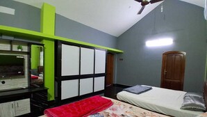 Un dormitorio con cama, escritorio, silla, armario y ventilador de techo.