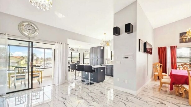 A modern interior with a kitchen, dining area, and a balcony with a view. - Waterfront 3BR 1Bath Furnished w/Gulf of America Access (NEW PORT RICHEY)