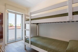 A bunk bed room with a sliding glass door leading to an outdoor area.